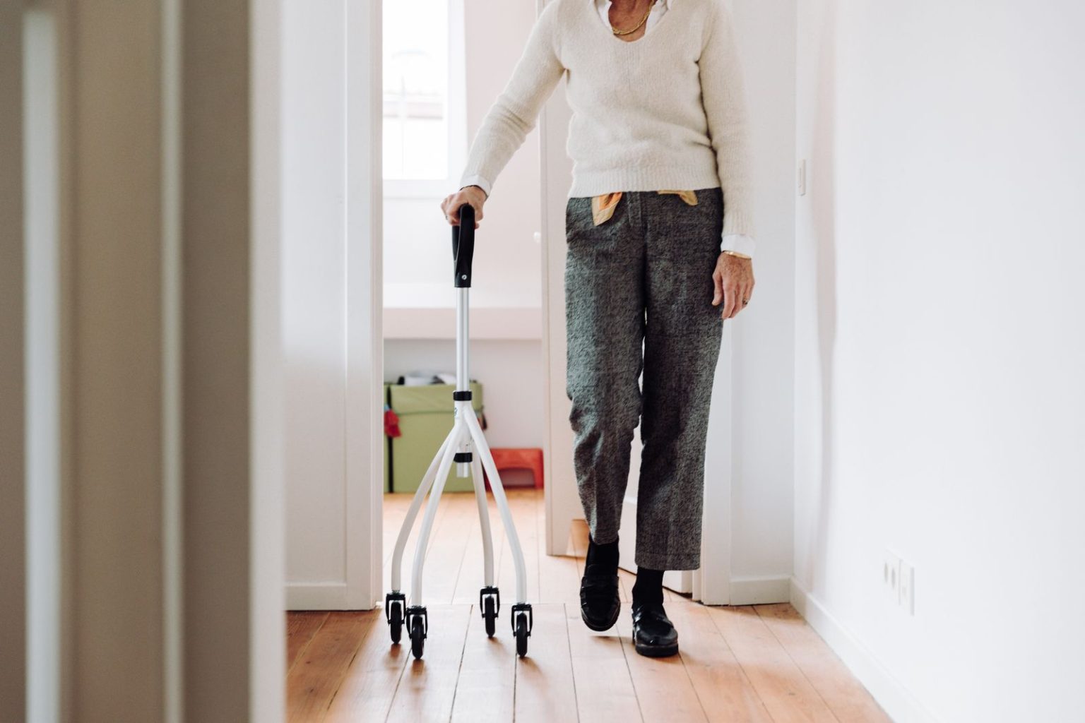An older adult walking at home with a rollator
