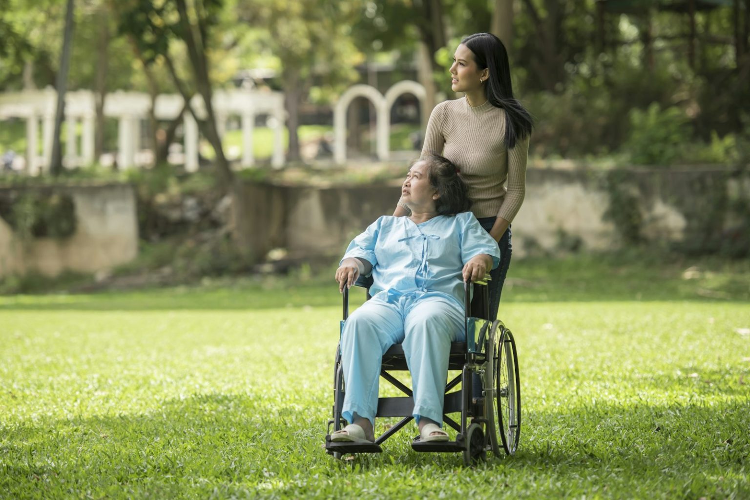 An older woman in a wheelchair enjoying time outdoors in a park
